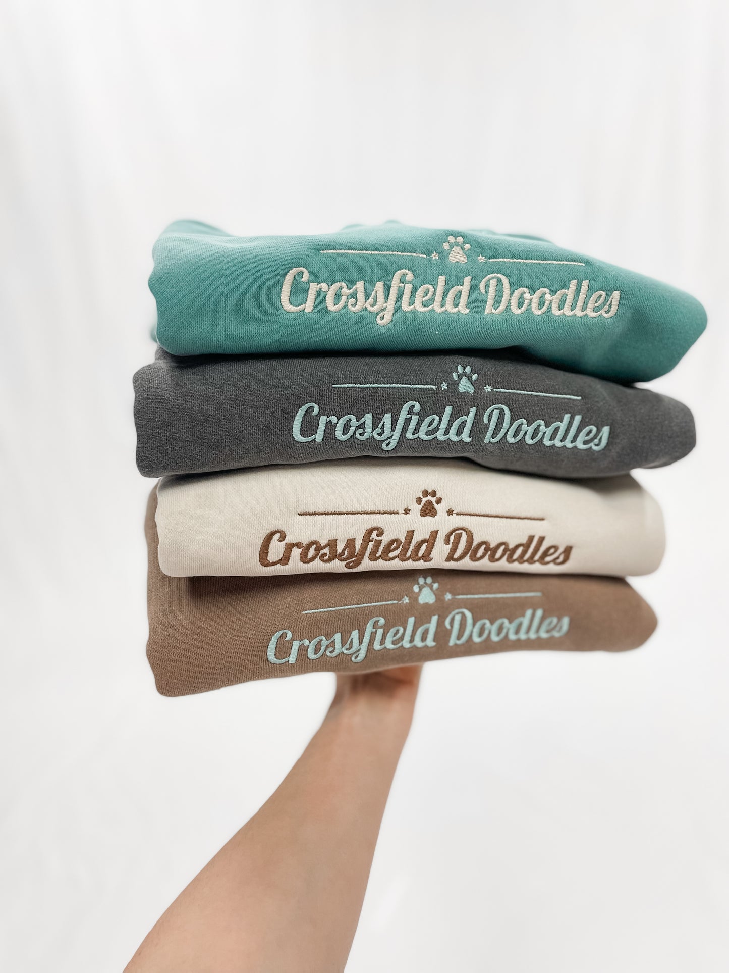 Stack of four sweatshirts with embroidered logos