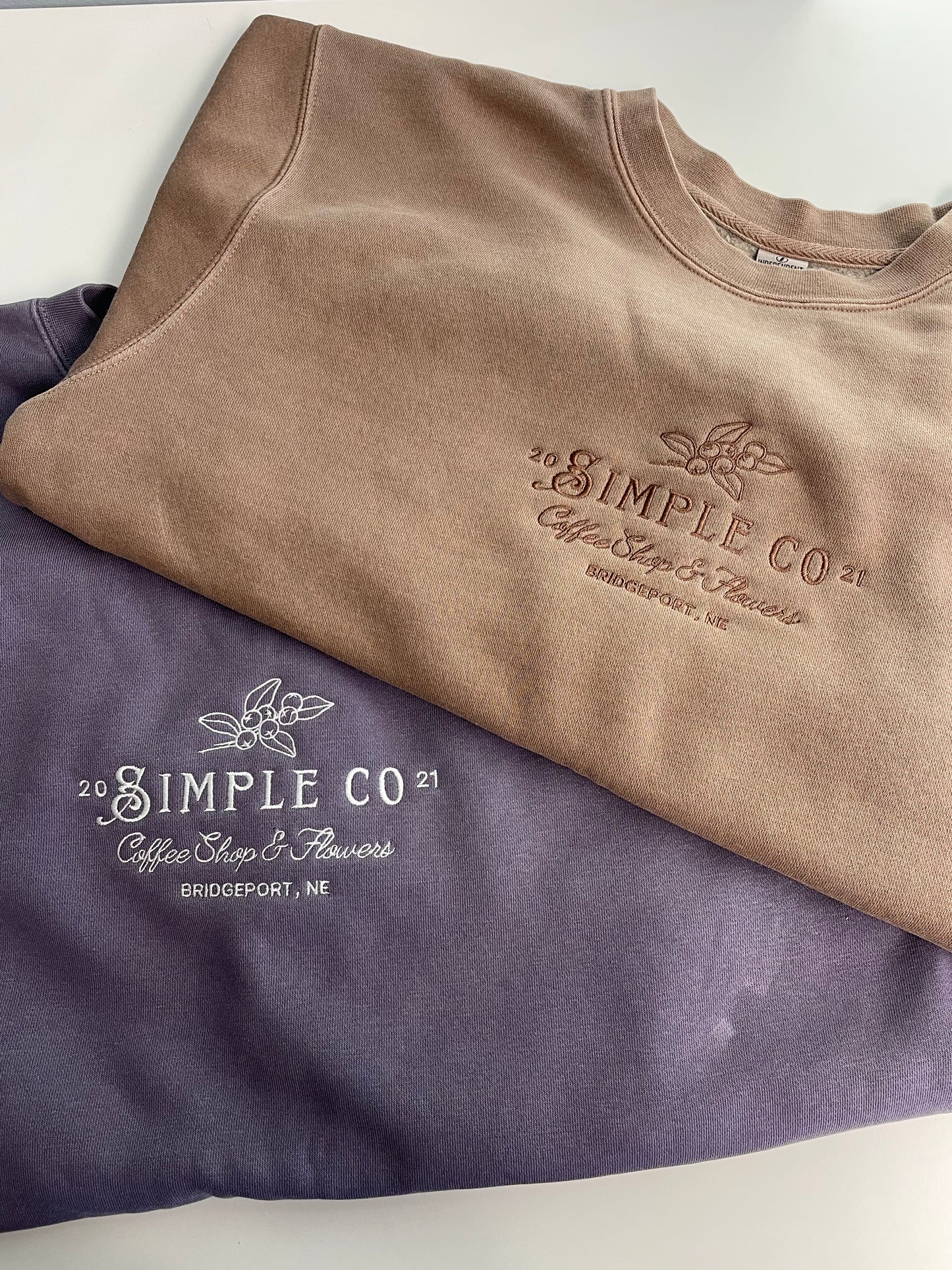 Two sweatshirts with custom logo embroidery