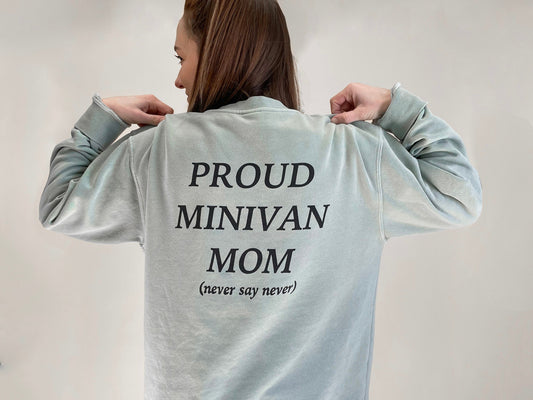 Back of sweatshirt featuring large letters proud minivan mom and small letters (never say never)